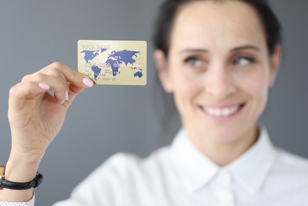 Mulher feliz segurando cartão de crédito de plástico