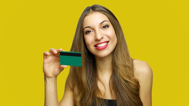 Foto mulher feliz segurando cartão de crédito isolado