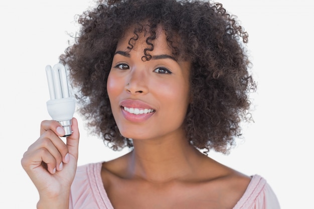 Mulher feliz segurando lâmpada de poupança de energia