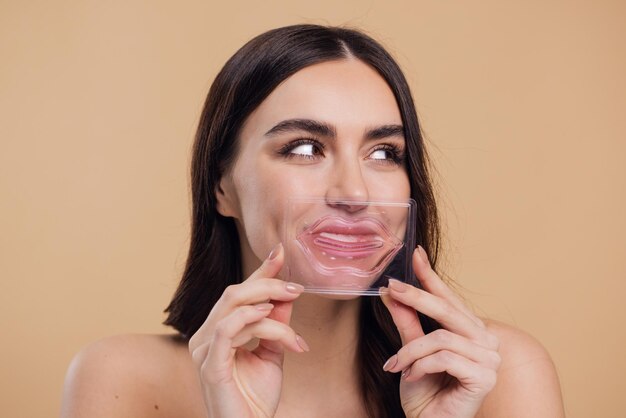 Mulher feliz segurando máscara de lábios de colágeno para lábios secos e rachados