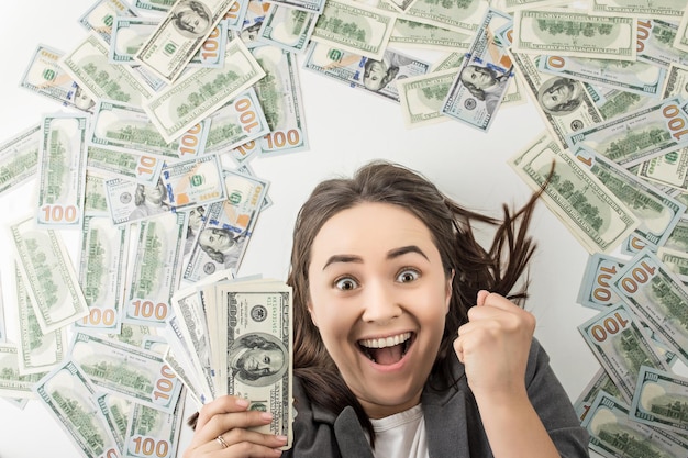 mulher feliz segurando uma pilha de notas de dólar