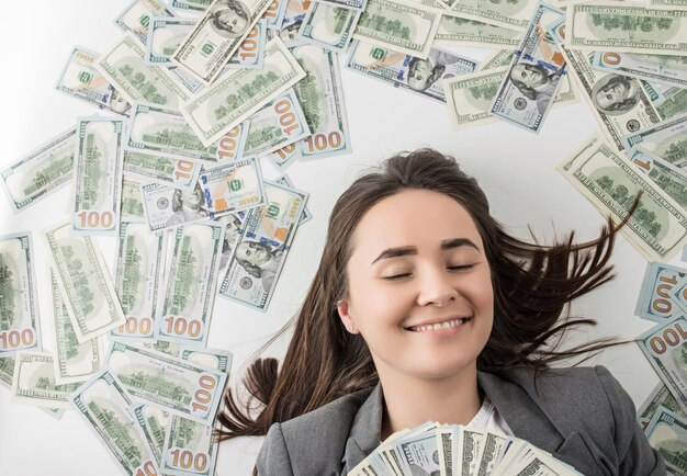 mulher feliz segurando uma pilha de notas de dólar