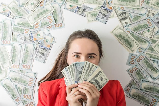 mulher feliz segurando uma pilha de notas de dólar