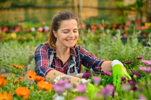 Mulher feliz sentada entre flores