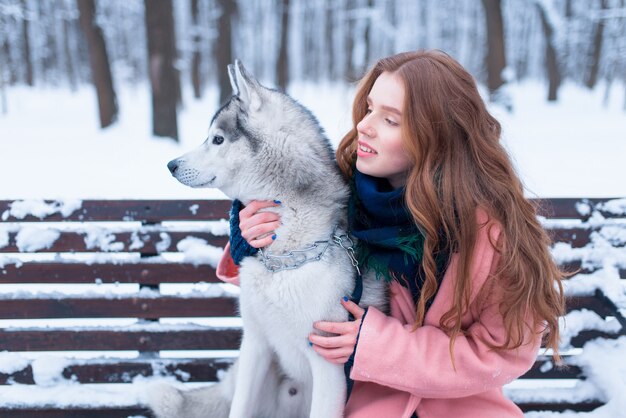 Mulher feliz sentada no banco com o husky