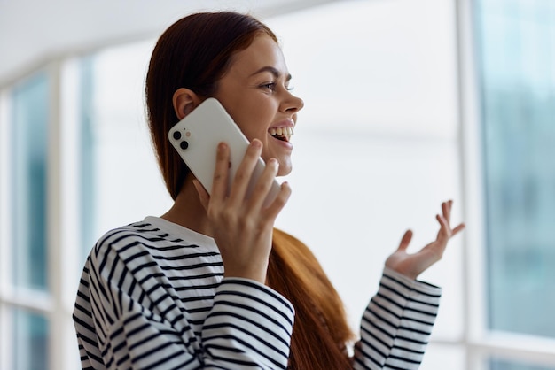 Foto mulher feliz sorri com dentes falando ao telefone retrato falando em um telefone inteligente pela internet trabalho online