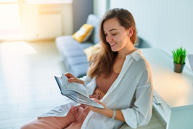 Mulher feliz sorridente lendo livro