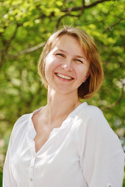 Mulher feliz sorrindo ao ar livre no verão