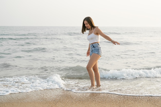 Mulher feliz sorrindo na beira da praia