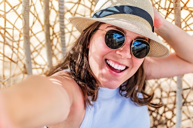 Mulher feliz tirando foto de selfie enquanto está sentado no parque de verão