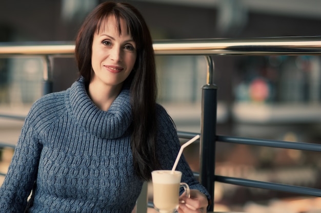 Mulher feliz tomando café no café