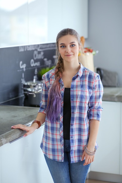 Mulher feliz tomando chá na cozinha de casa