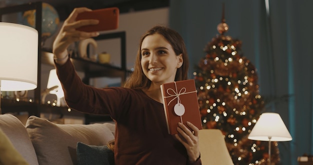 Mulher feliz tomando uma selfie com seu presente de Natal