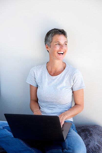 Mulher feliz usando computador portátil e desviar o olhar