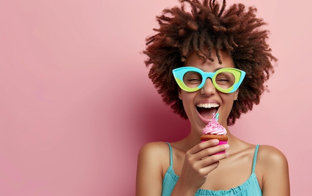 Mulher feliz usando óculos de novidade segurando cupcake Celebração de aniversário