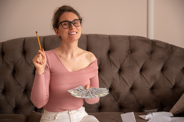 Mulher feliz usando óculos escuros, mostrando dinheiro