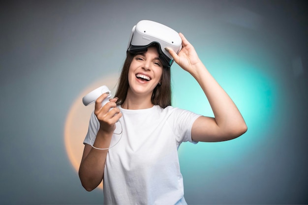 Mulher feliz usando um fone de ouvido de realidade virtual isolado em fundo colorido