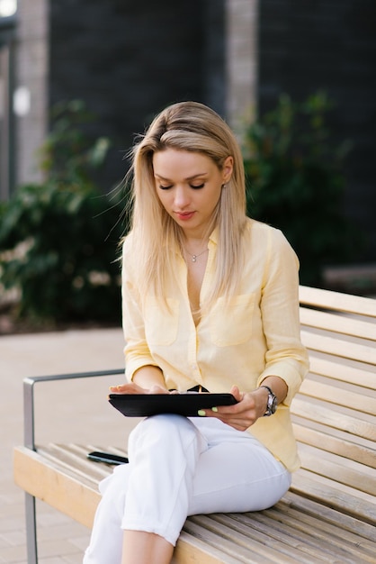 Mulher feliz usando um tablet ao ar livre