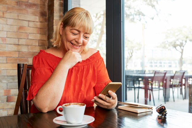 Mulher feliz, verificando seu telefone