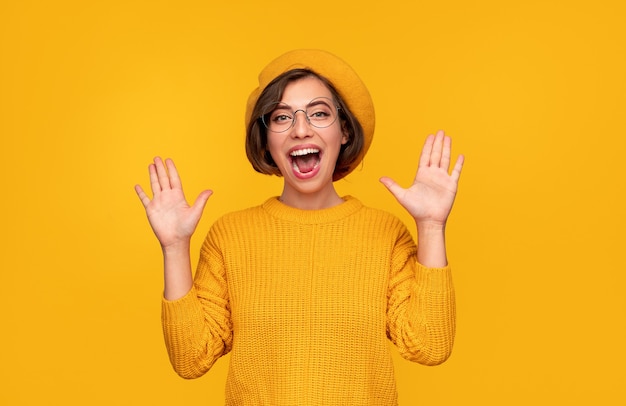 Mulher feliz vestida de amarelo comemorando o sucesso