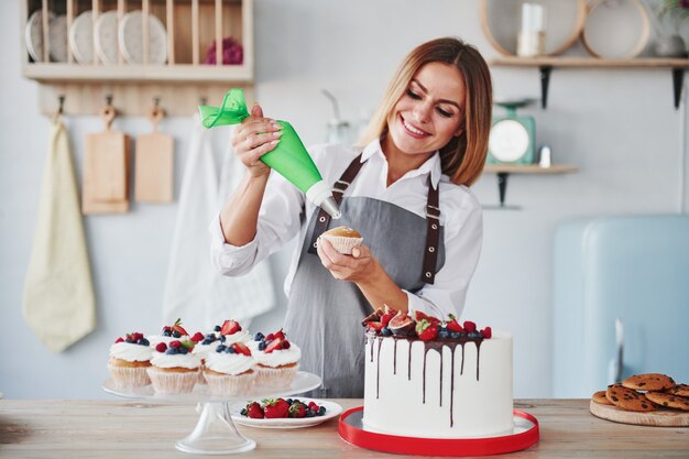 Mulher fica dentro de casa na cozinha com torta caseira.