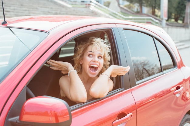 Mulher fica perto de um carro quebrado após um acidente, liga para o seguro automóvel