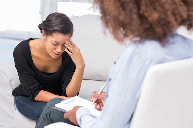 Mulher ficando deprimido no sofá em terapia