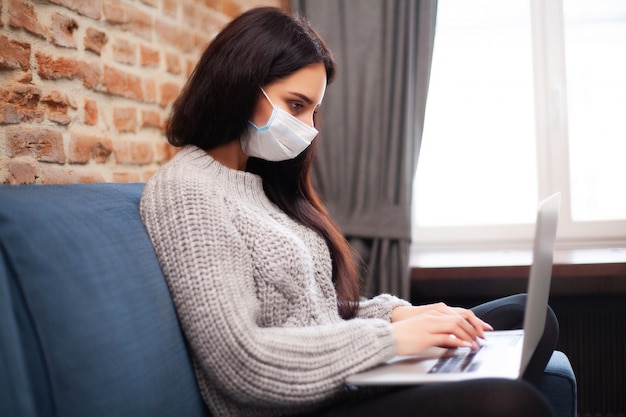 Mulher ficar em casa durante uma epidemia e trabalhando em um laptop