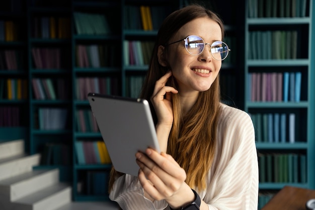 Mulher financeira com óculos escreve uma mensagem para um trabalho de escritório tablet