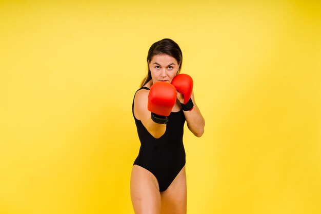 Mulher fitness com ataduras de boxe vermelho e fotos de estúdio de luvas