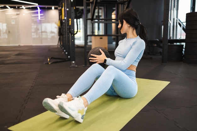 Mulher fitness fazendo exercícios com medicine ball na academia