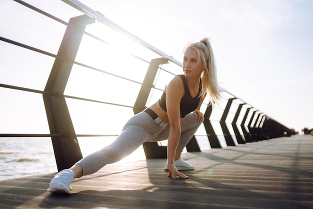 Mulher fitness fazendo exercícios esportivos no cais da praia Estilo de vida saudável Esporte Vida ativa