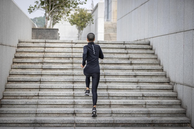 Mulher fitness subindo escadas na cidade