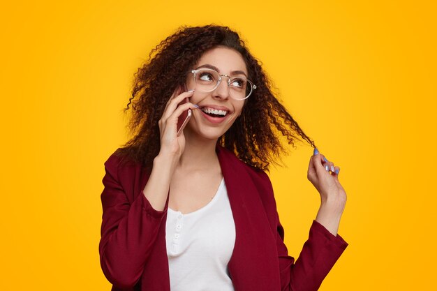 Foto mulher flertando falando no smartphone e tocando o cabelo