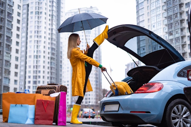 Mulher flexível segurando a divisão e tirando as malas do carro flexibilidade ioga alongamento e saúde ...