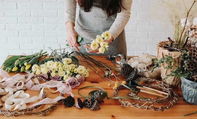 Mulher florista recolhe bouquet decora diferentes flores