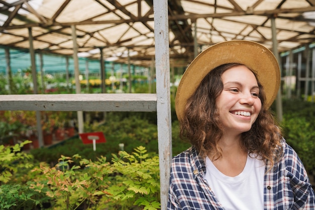 Mulher florista trabalhando em estufa sobre plantas