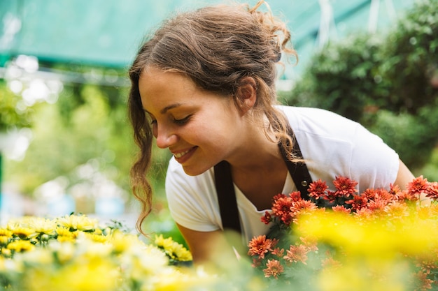 Mulher florista trabalhando em estufa sobre plantas