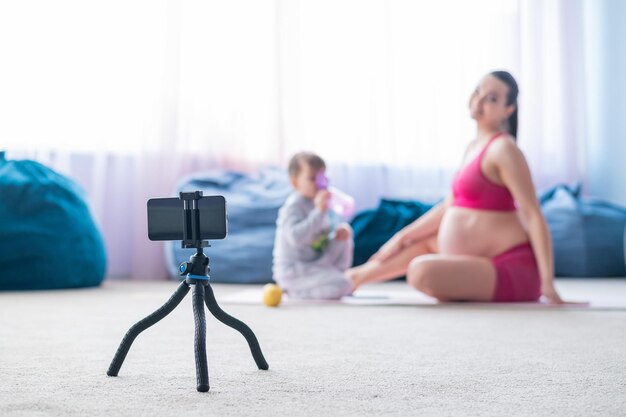 Mulher fotografando sentada na cama em casa