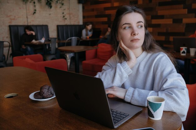 Mulher freelance feliz trabalhando em um café remotamente