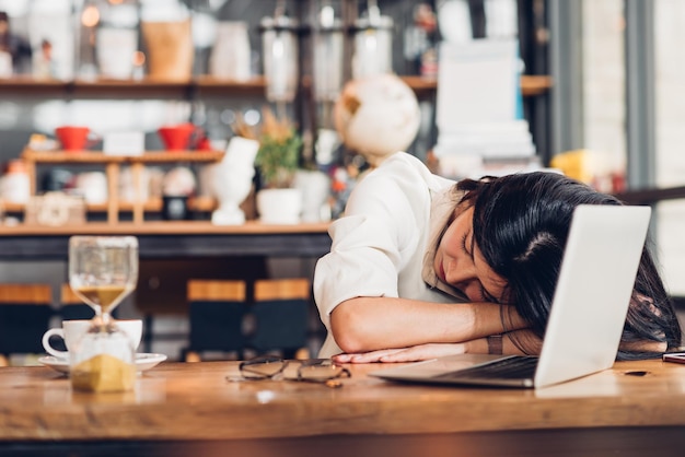 Mulher freelancer de estilo de vida que ele descansa dormindo depois de muito trabalho duro na cafeteria