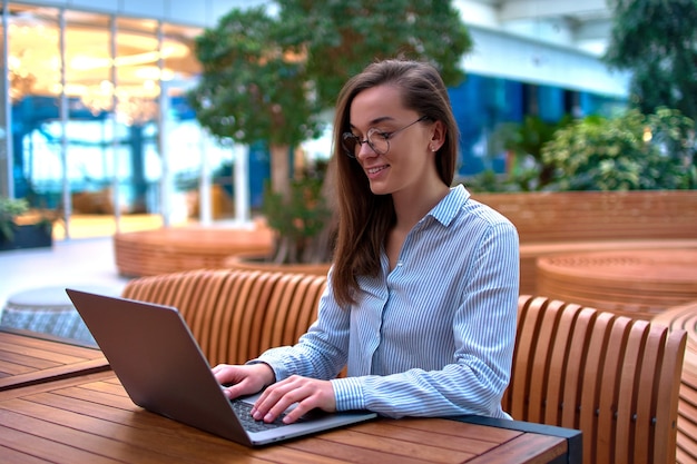 Mulher freelancer inteligente e moderna trabalhando remotamente on-line em um laptop