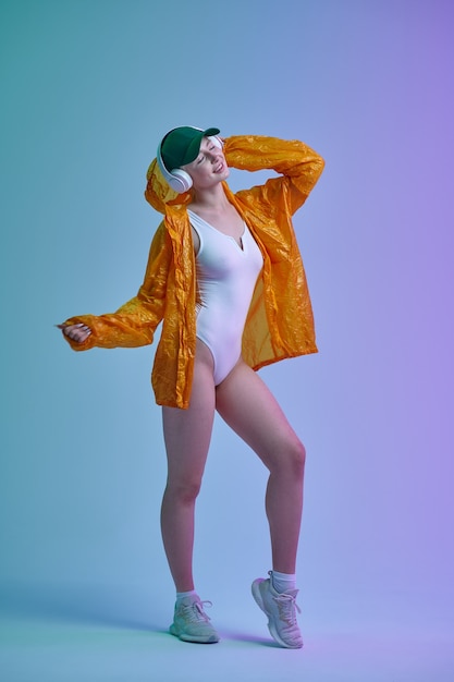 Mulher futurista com capa de chuva, boné e fones de ouvido