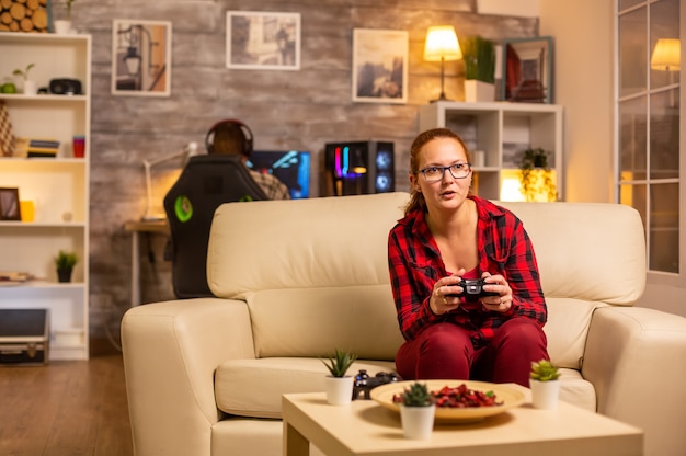 Mulher gamer jogando videogame no console da sala de estar tarde da noite