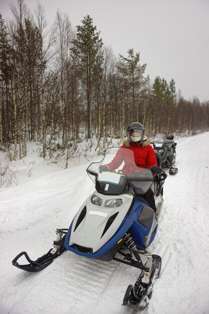 Mulher gerenciando snowmobile em Ruka da Lapônia