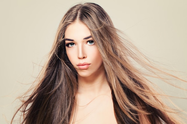 Mulher glamorosa com cabelo castanho natural e maquiagem. Linda modelo com penteado longa e saudável