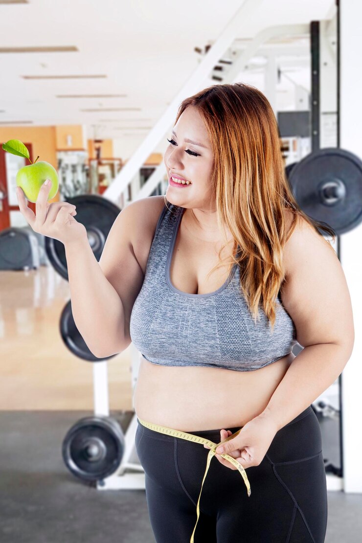 Foto mulher gorda com maçã e fita métrica