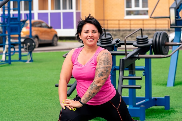 Mulher gorda e musculosa fazendo exercícios no campo esportivo