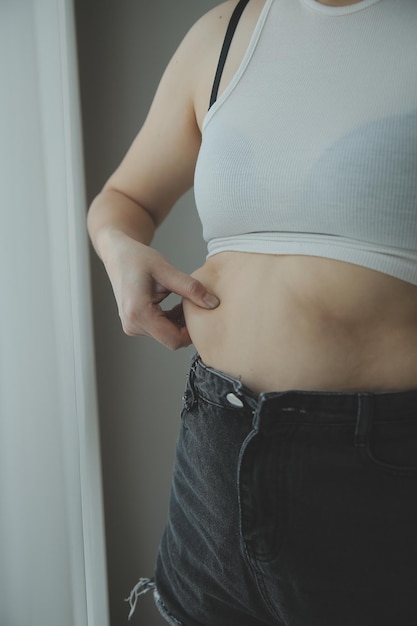 Foto mulher gorda medindo mulher gorda barriga gordinha barriga gorda desporto recreação cuidados de saúde perder gordura da barriga não se exercitar conceito