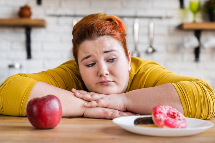 Foto mulher gorda triste escolhendo entre doces e frutas, comida saudável e junk food, a escolha de duas opções, a escolha entre comer delema para um estilo de vida saudável ou não.